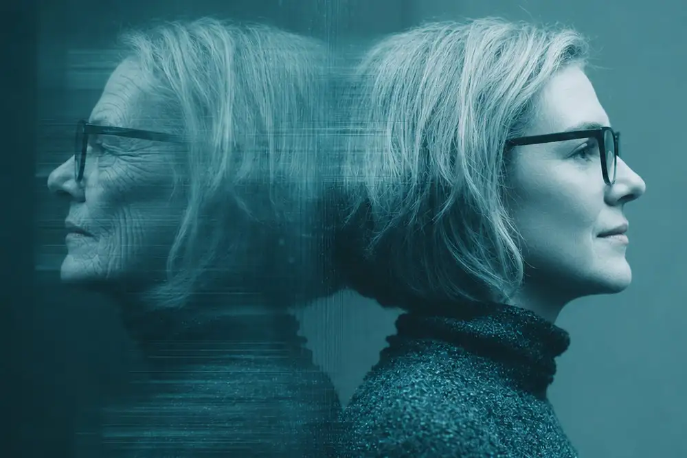 Profil einer Frau mit Brille, angelehnt an eine spiegelnde Wand in Blautönen.